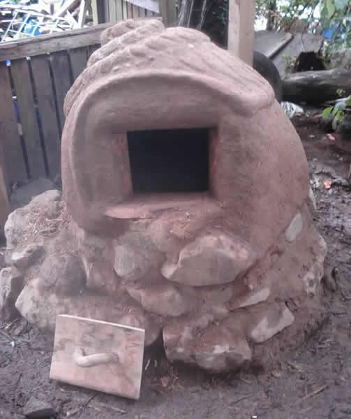 Earth oven and door in the shape of a snail with pebble mosaic