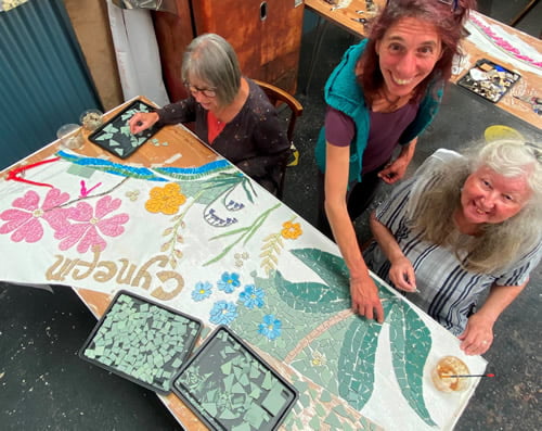 Dani Lee and 2 participants making a community mosaic